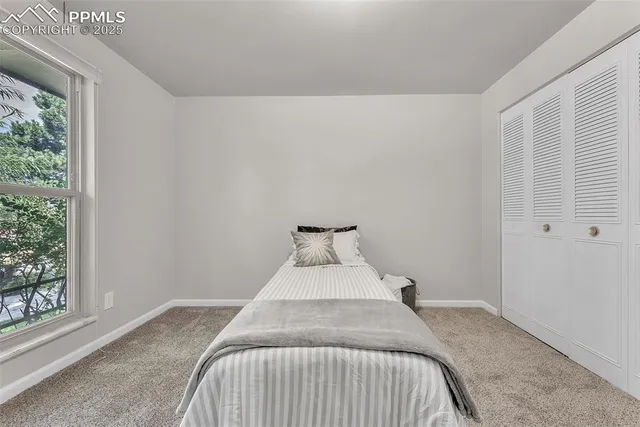 a bed sitting in a bedroom next to a window