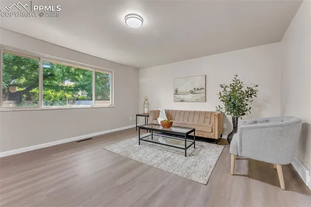 a living room with furniture a window and a potted plant