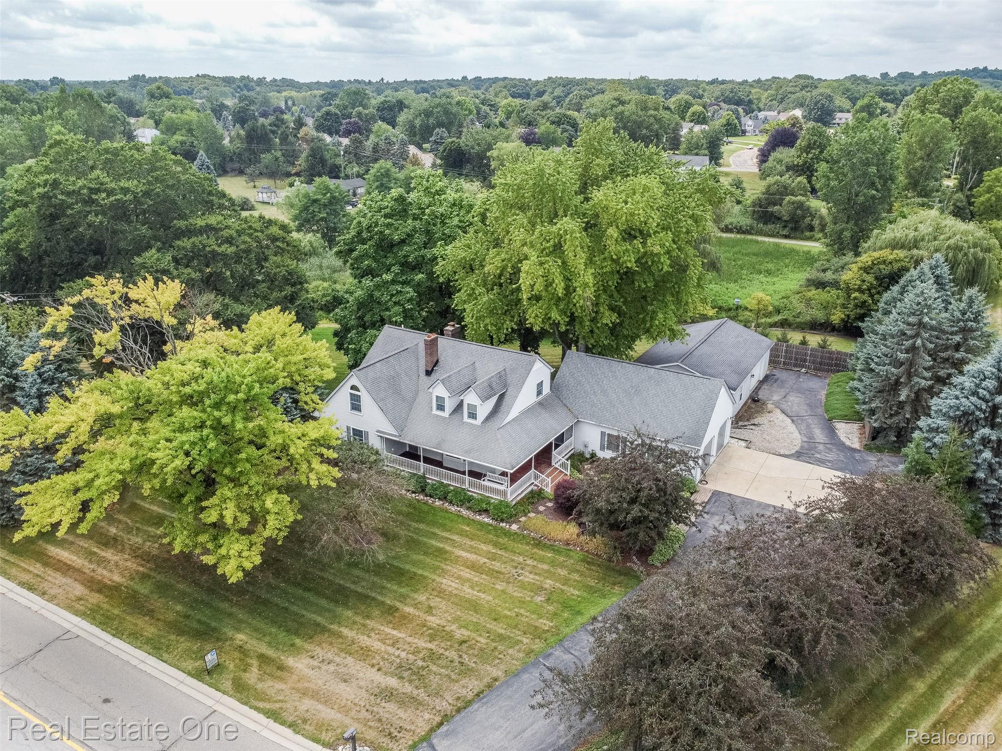 11030 Marshall Road South Lyon, MI 48178 - Photo 2 of 83 Elegant Colonial-style residence set on expansive grounds featuring manicured lawns, mature landscape plantings, and established trees