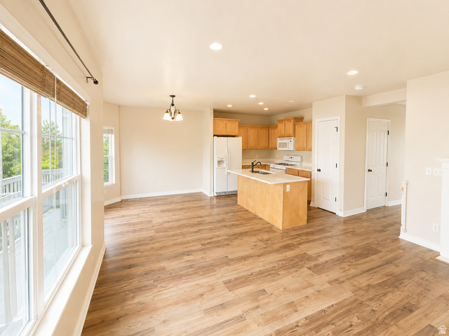 14767 Invergarry Court Draper, UT 84020 - Photo 1 of 18 Open-concept living space featuring wood-finish flooring, recessed lighting, and a kitchen island with a light-colored countertop