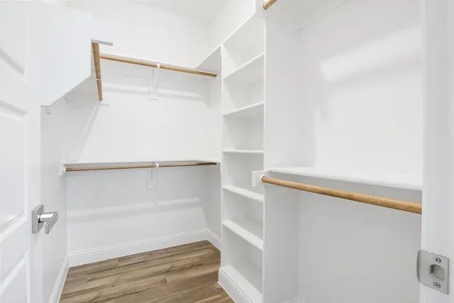 a view of walk in closet with empty racks