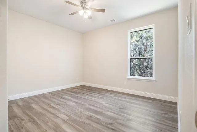 wooden floor in an empty room with a window