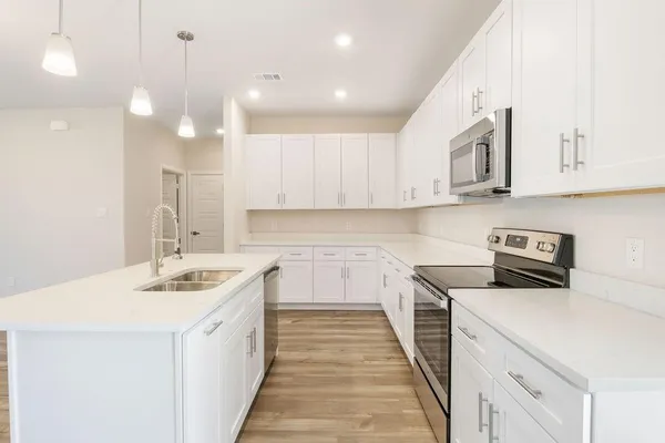 a kitchen with a sink stove and refrigerator