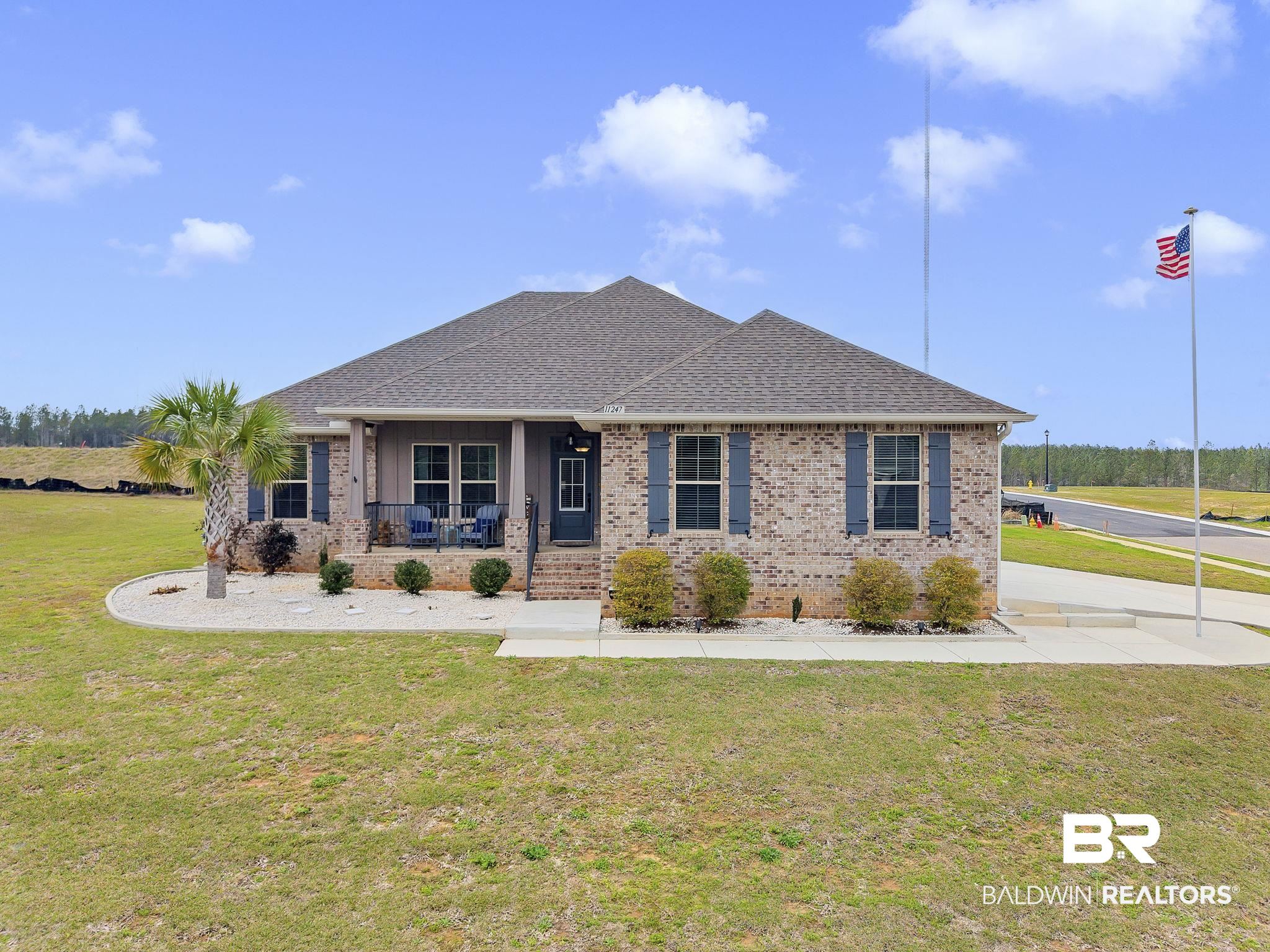 11247 Thistledown Loop Spanish Fort, AL 36527 - Photo 64 of 72 View of front of house featuring a porch, roof with shingles, brick siding, and a front lawn