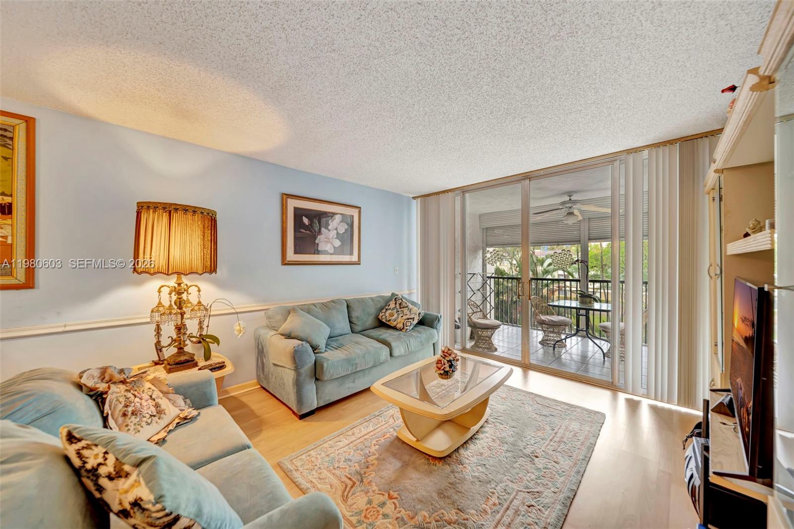 3940 Inverrary Boulevard, Unit 303A Lauderhill, FL 33319 - Photo 4 of 28 a living room with furniture and a flat screen tv