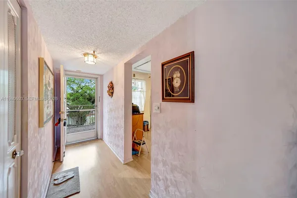 a view of a hallway with wooden floor and windows