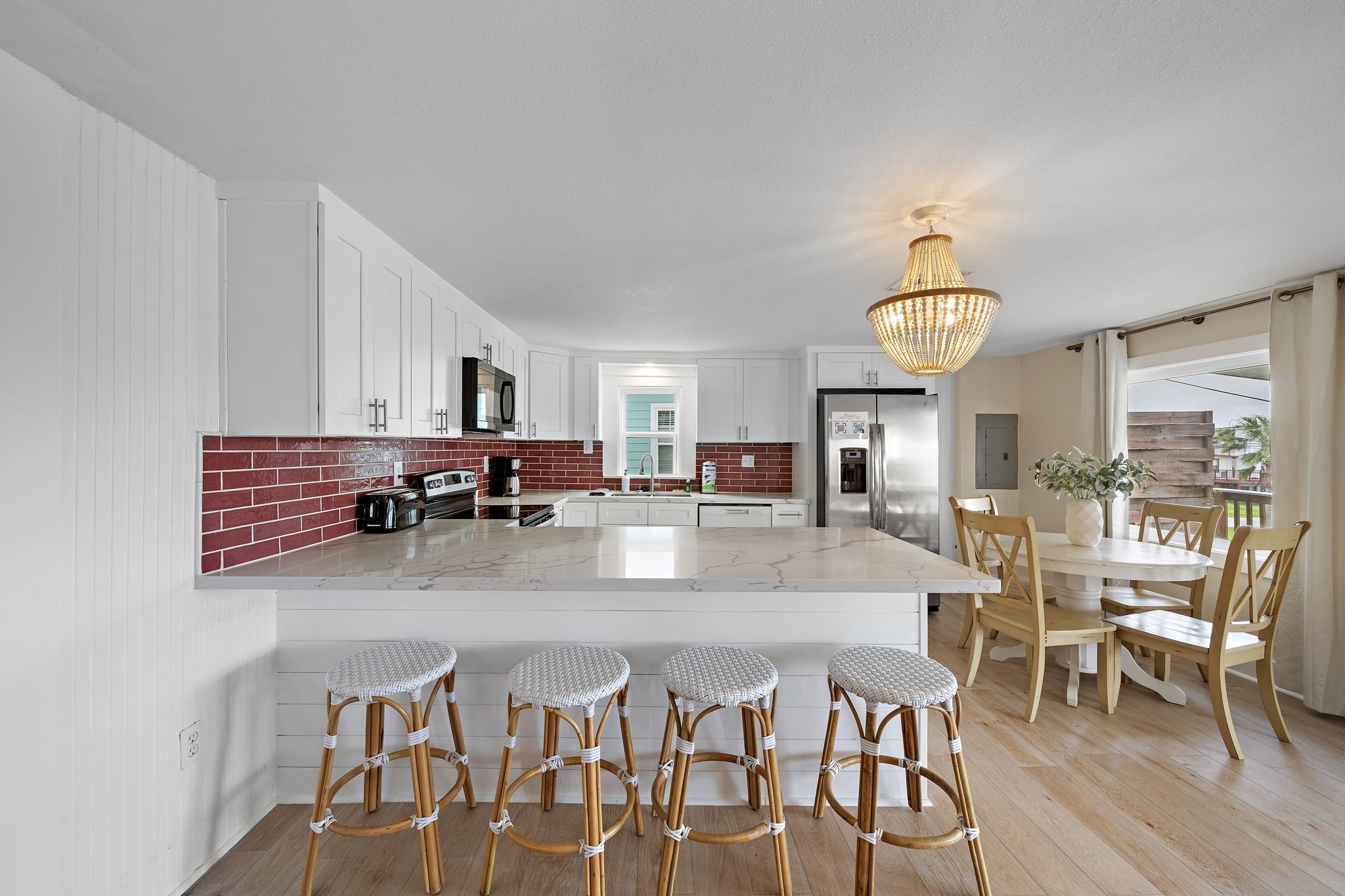 417 Olive Street Surfside Beach, TX 77541 - Photo 11 of 46 a dining room with furniture a chandelier and wooden floor