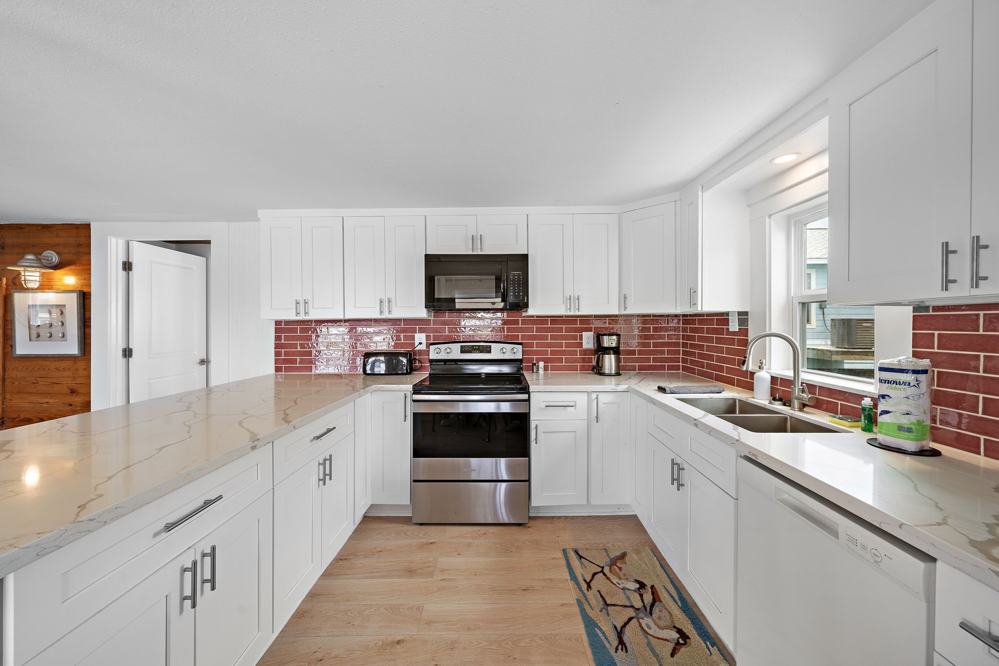 417 Olive Street Surfside Beach, TX 77541 - Photo 13 of 46 a kitchen with stainless steel appliances granite countertop a stove top oven a sink dishwasher and a refrigerator with wooden floor