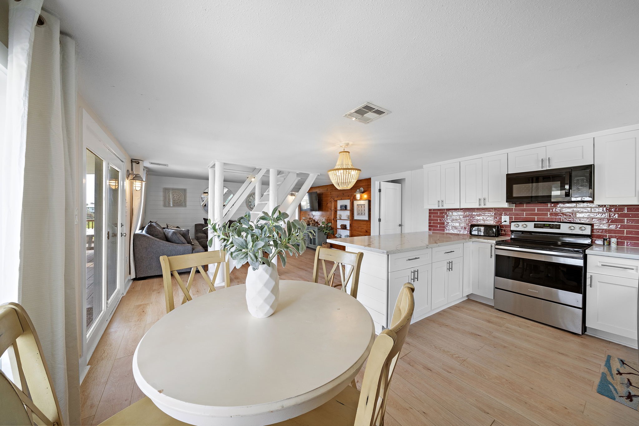 417 Olive Street Surfside Beach, TX 77541 - Photo 17 of 46 a open kitchen with stainless steel appliances kitchen island granite countertop a sink a stove a dining table and chairs