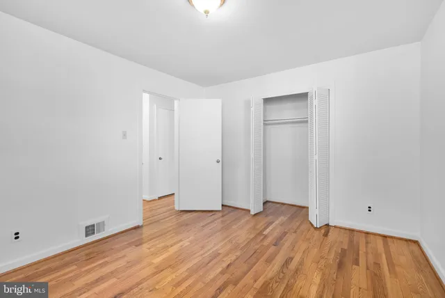 a view of an empty room with wooden floor