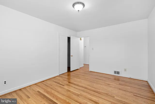 a view of empty room with wooden floor