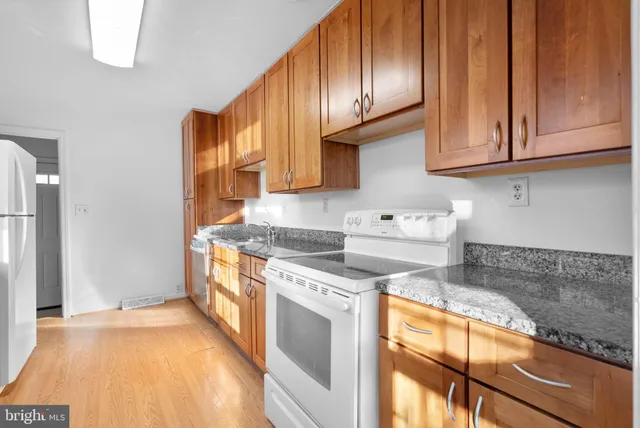 a kitchen with stainless steel appliances granite countertop a stove a sink and a refrigerator