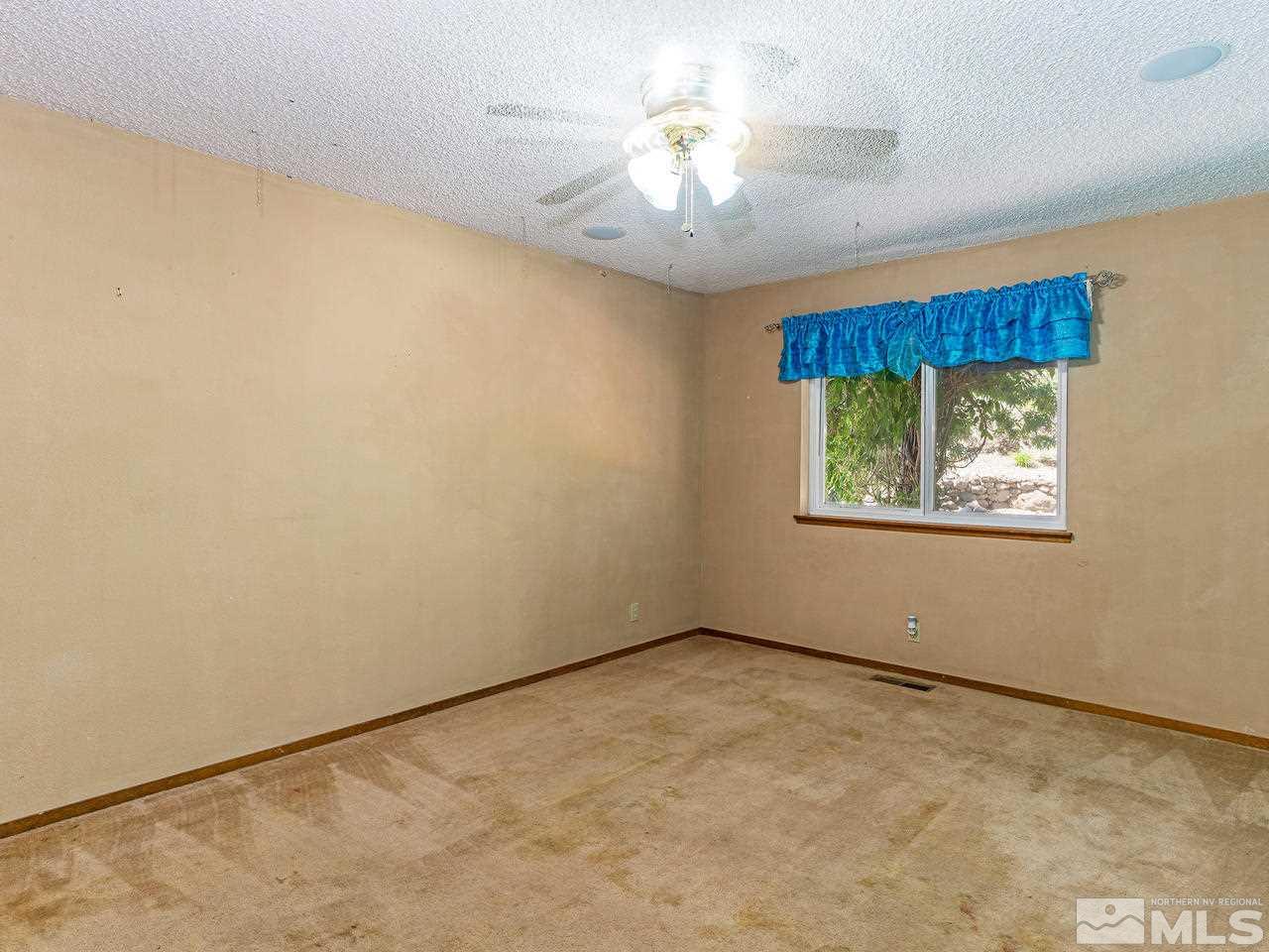 13055 Thomas Creek Road Reno, NV 89511 - Photo 13 of 24 an empty room with a chandelier fan and windows