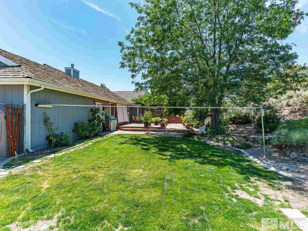 13055 Thomas Creek Road Reno, NV 89511 - Photo 21 of 24 a backyard of a house with table and chairs plants and large tree