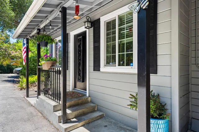 a view of a porch with chairs and potted plants