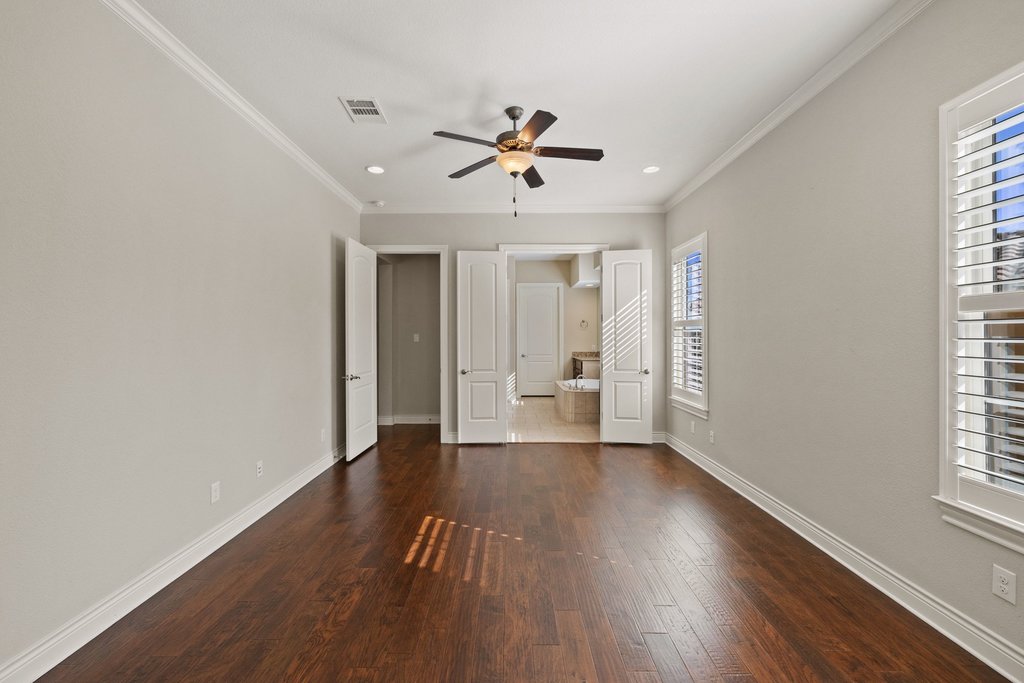404 Amiata Avenue, Unit 34 Austin, TX 78734 - Photo 12 of 26 an empty room with wooden floor a ceiling fan and windows