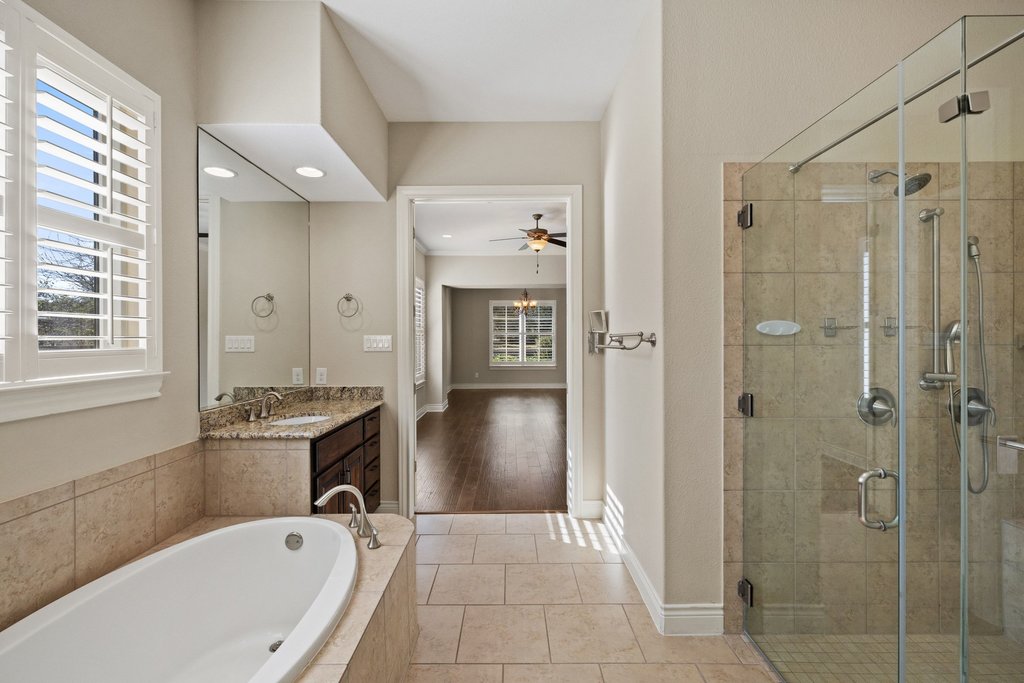 404 Amiata Avenue, Unit 34 Austin, TX 78734 - Photo 15 of 26 a bathroom with a granite countertop tub sink shower and mirror