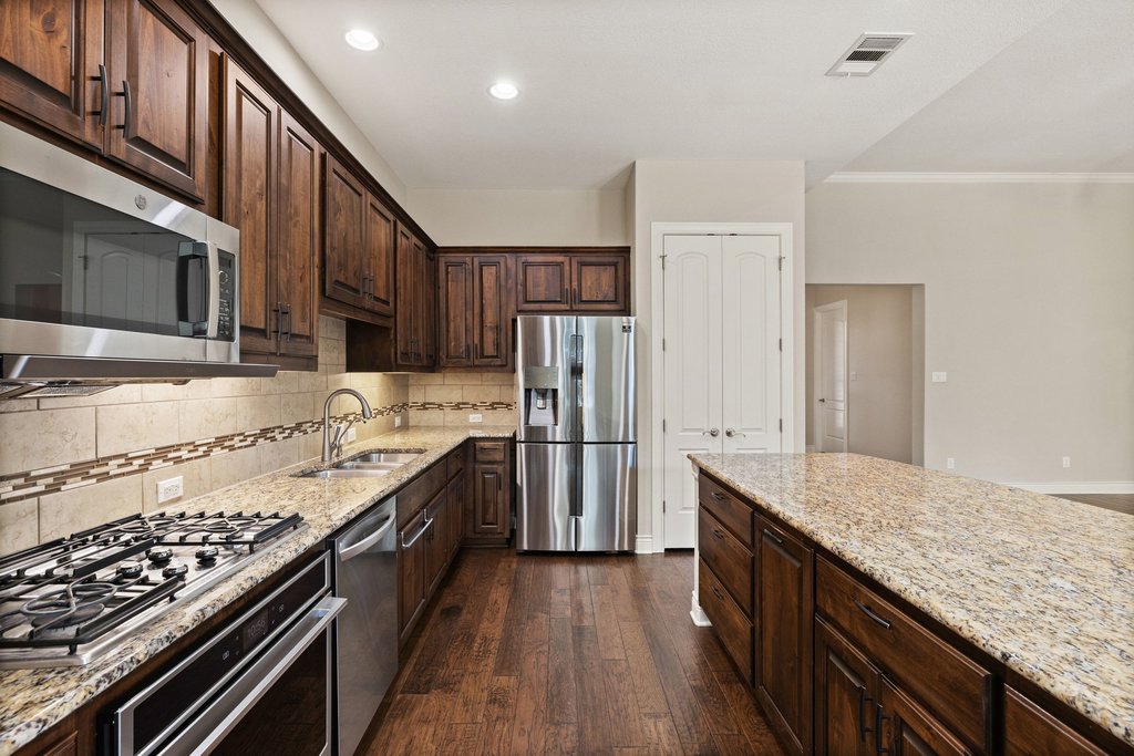 404 Amiata Avenue, Unit 34 Austin, TX 78734 - Photo 5 of 26 a kitchen with stainless steel appliances granite countertop a stove top oven a sink and dishwasher