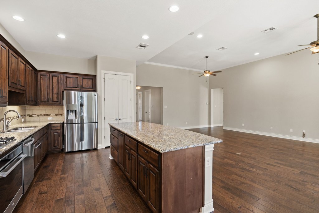 404 Amiata Avenue, Unit 34 Austin, TX 78734 - Photo 6 of 26 a kitchen with stainless steel appliances granite countertop a kitchen island a hardwood floor and a sink