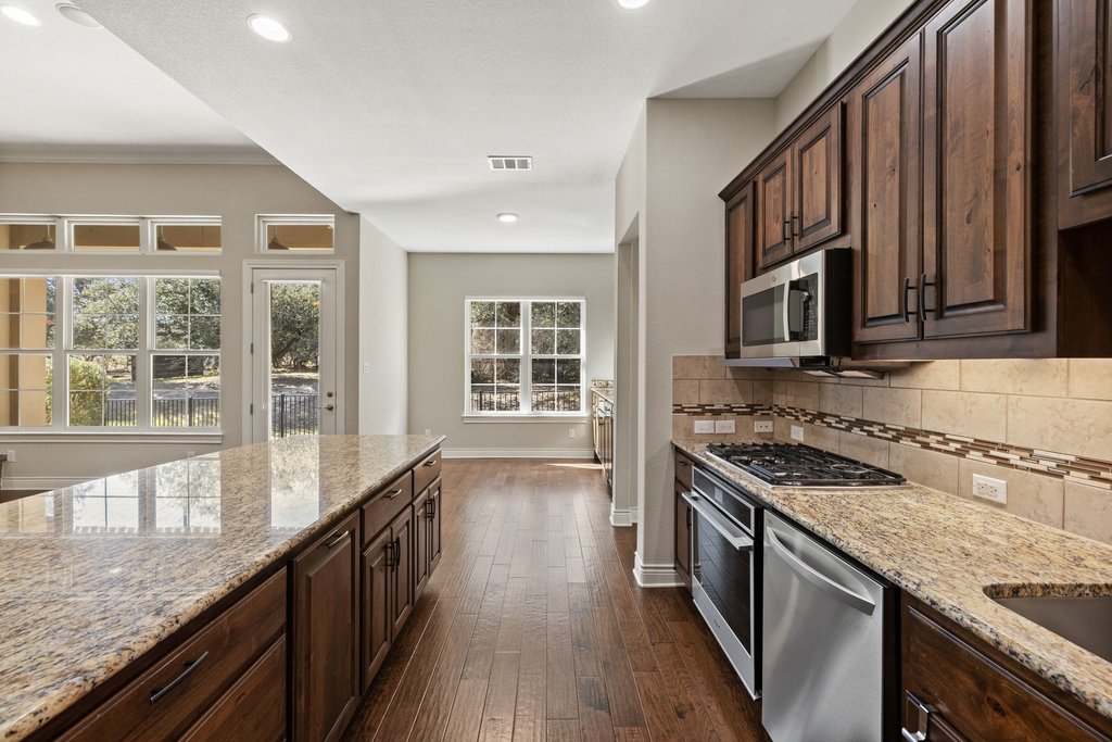 404 Amiata Avenue, Unit 34 Austin, TX 78734 - Photo 7 of 26 a kitchen with granite countertop a stove and a sink