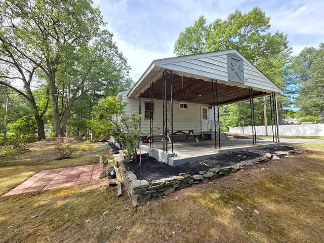 a view of a patio with table and chairs under an umbrella