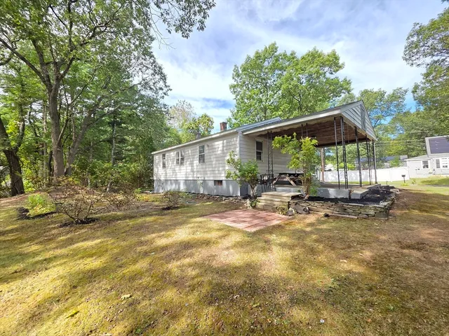 a view of a house with backyard and sitting area