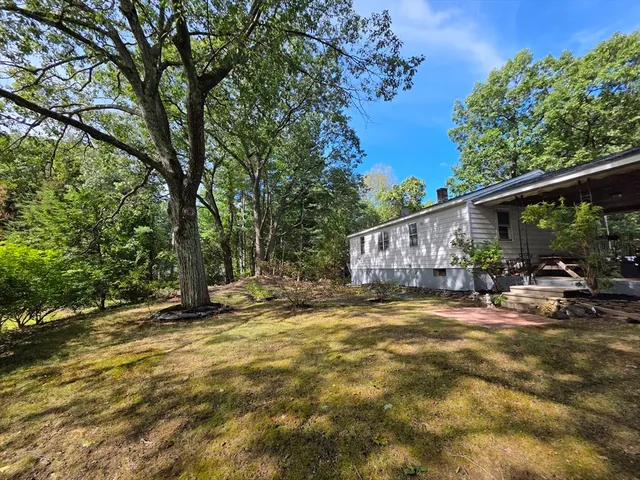 a view of a house with backyard and sitting area
