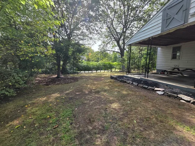 a backyard of a house with barbeque oven table and chairs