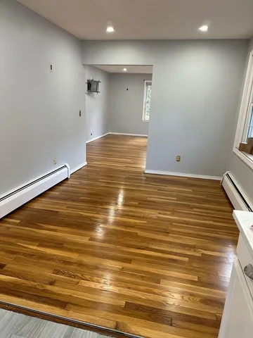 a view of room with window and wooden floor