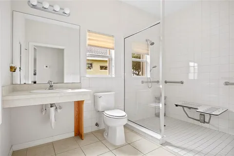 a bathroom with a sink a toilet and shower