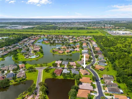 an aerial view of ocean and residential houses with outdoor space