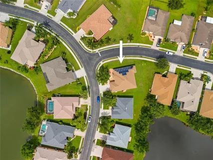 an aerial view of a house with a yard and pool