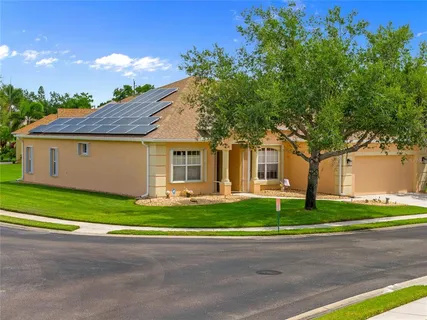 a front view of a house with a garden and trees