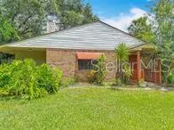 a view of a house with backyard and sitting area