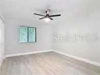 en empty room with window and a ceiling fan