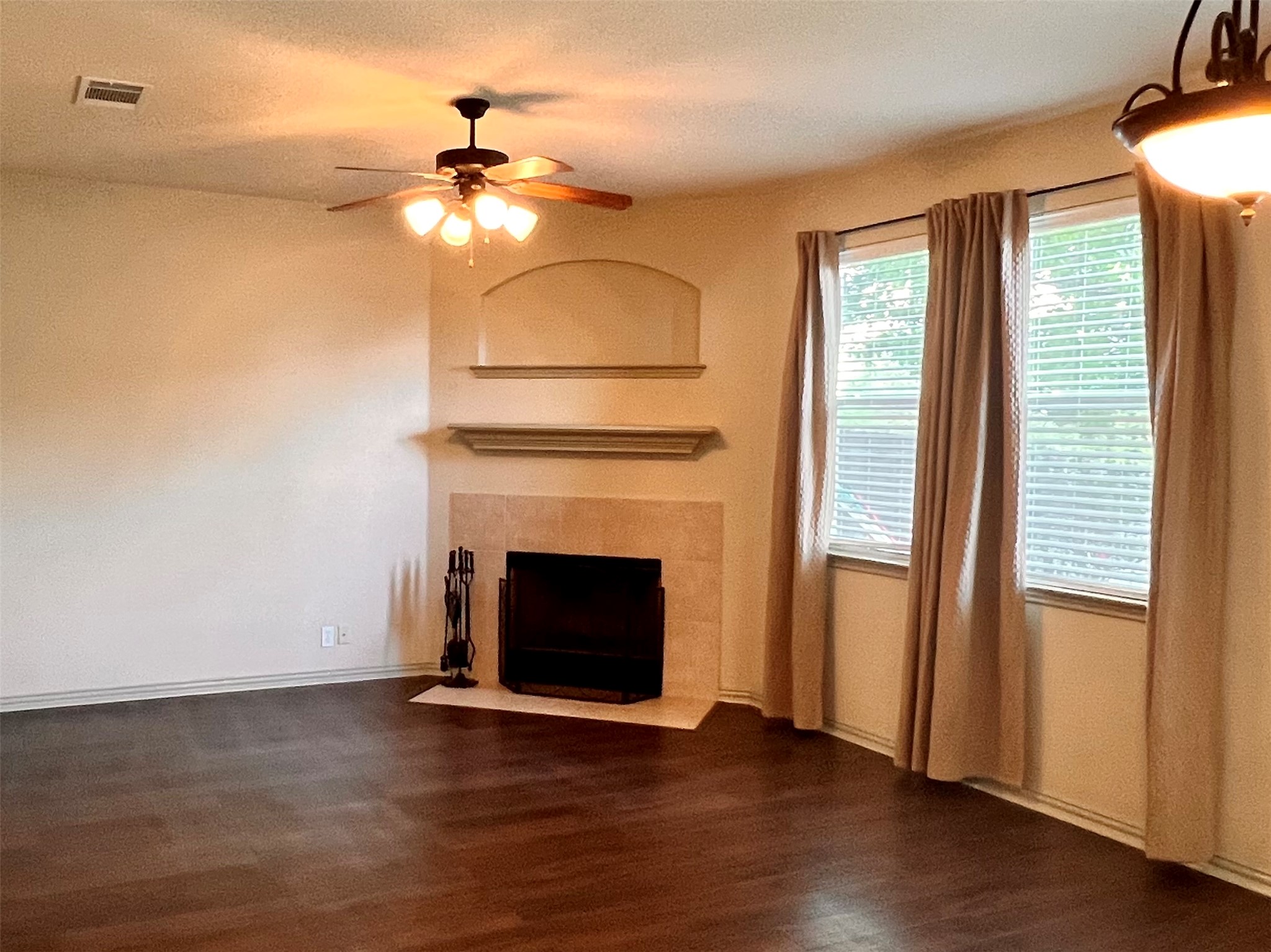 16616 Bridgefarmer Boulevard Pflugerville, TX 78660 - Photo 8 of 36 an empty room with wooden floor fireplace and windows