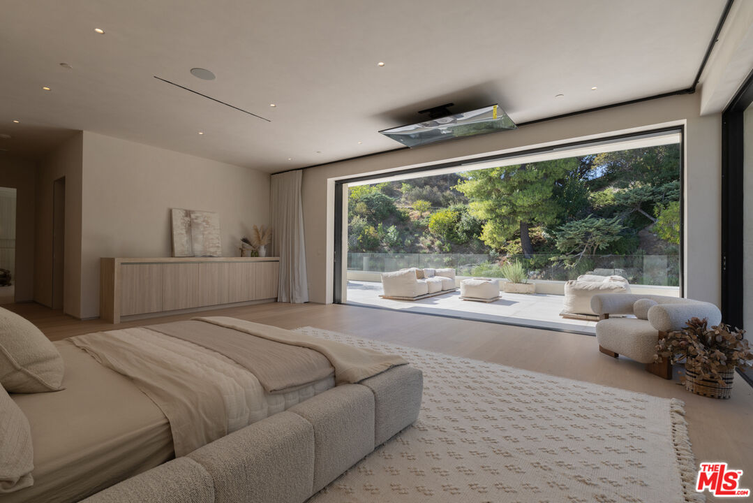 17177 Adlon Road Encino, CA 91436 - Photo 10 of 20 a bedroom with a large bed and a large window