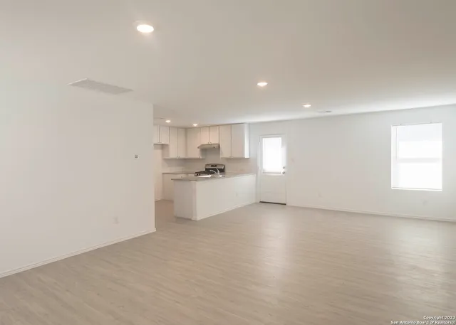 a view of a kitchen with white cabinets and wooden floor