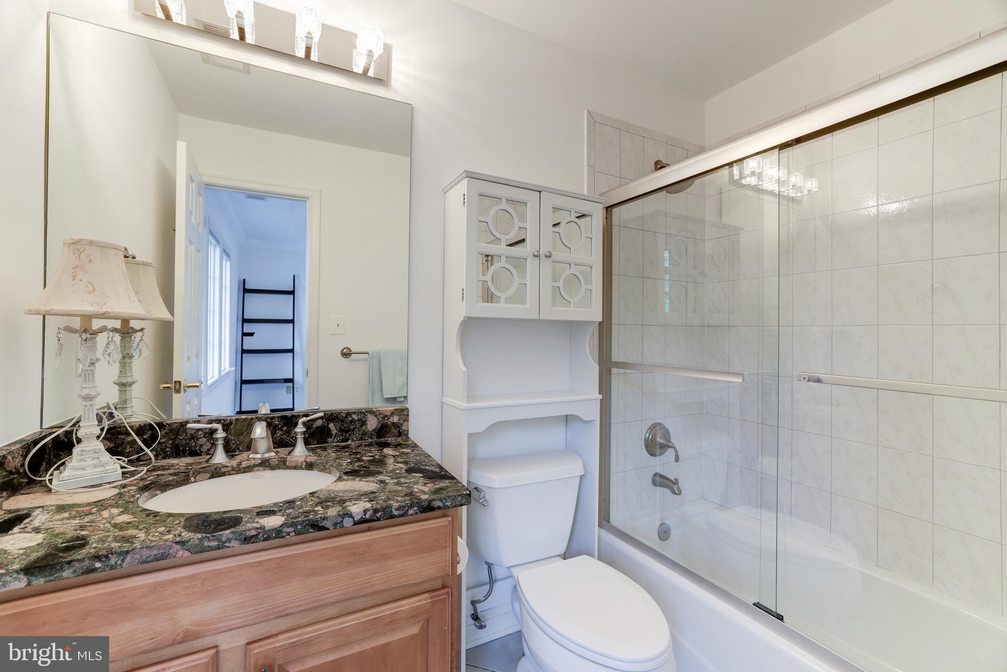 6318 Georgetown Pike McLean, VA 22101 - Photo 30 of 47 a bathroom with a granite countertop sink toilet and shower