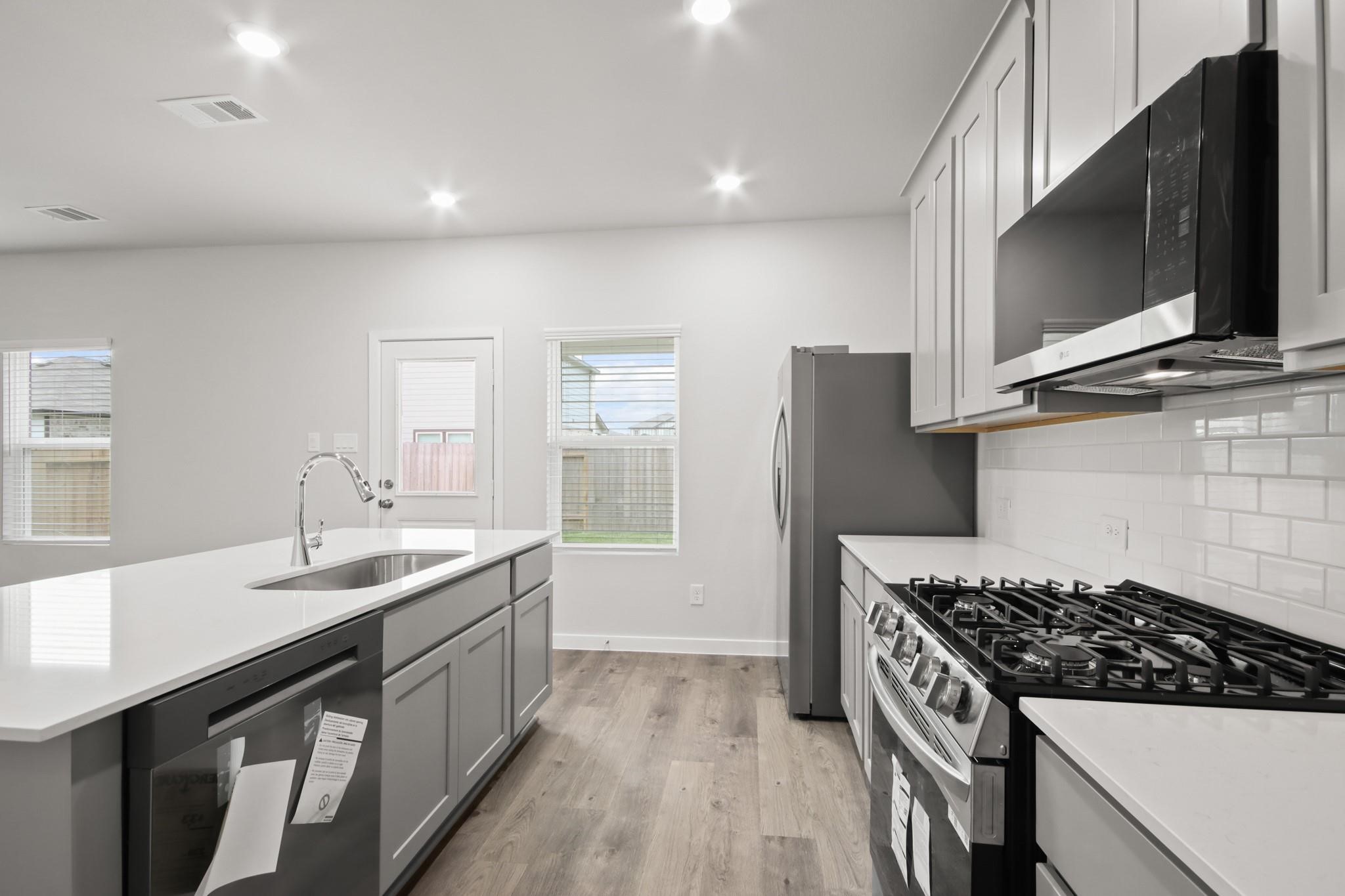 227 Brazen Forest Trail Magnolia, TX 77354 - Photo 6 of 22 a kitchen with a sink stove and microwave
