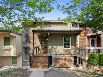 a front view of a house with a tree