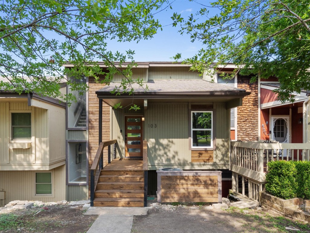 a front view of a house with a tree