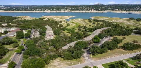 an aerial view of residential house with outdoor space and trees all around
