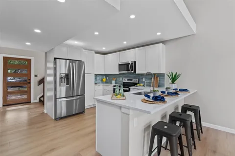 a kitchen with stainless steel appliances a refrigerator stove microwave and cabinets