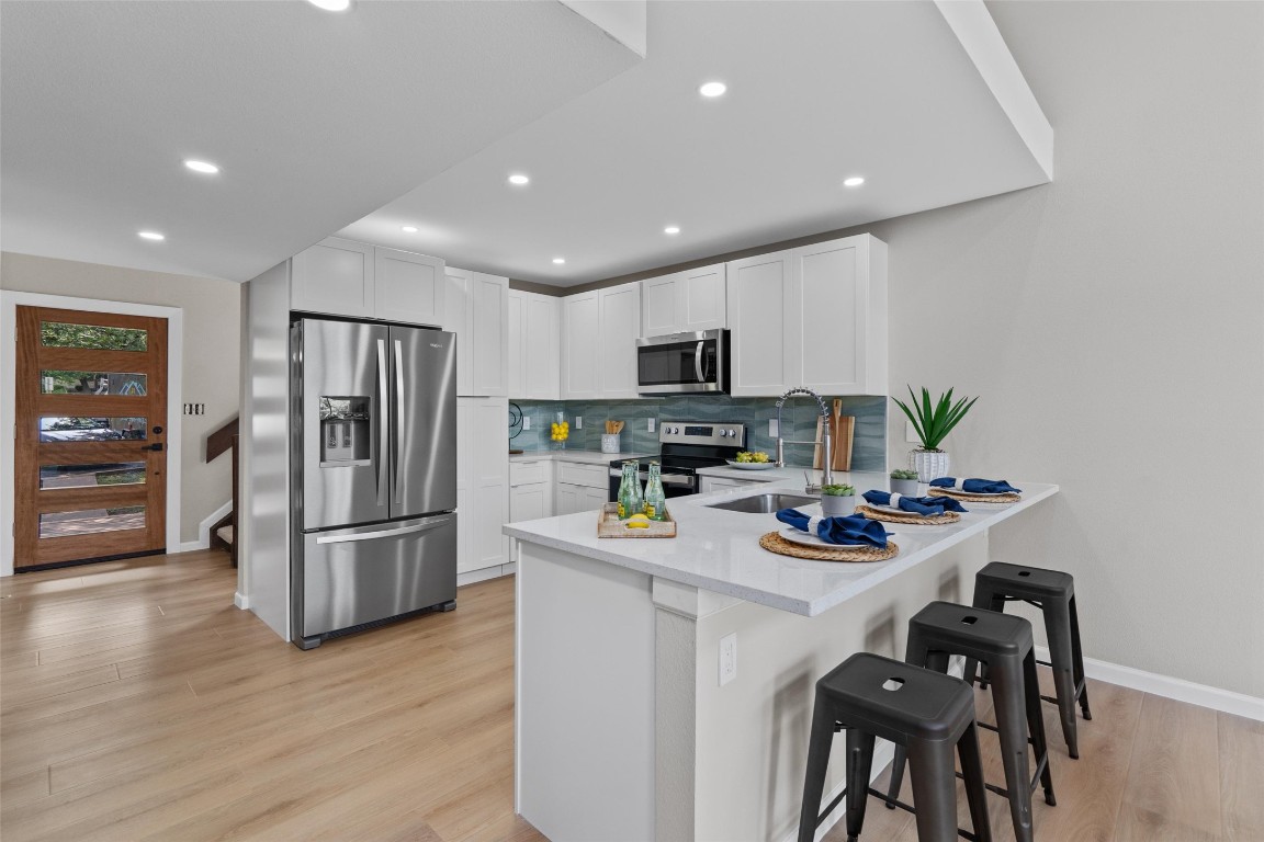 103 Comanche Drive Point Venture, TX 78645 - Photo 5 of 38 a kitchen with stainless steel appliances a refrigerator stove microwave and cabinets