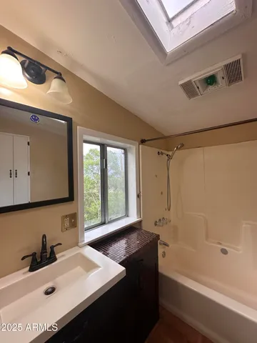 a bathroom with a tub sink and mirror