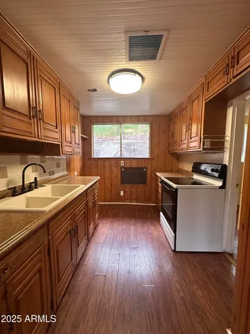 a kitchen with stainless steel appliances wooden floors and wooden cabinets