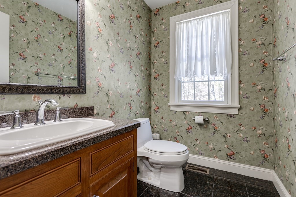 97 Glenwood Road Rutland, MA 01543 - Photo 11 of 26 a bathroom with a granite countertop toilet a sink a mirror and a window