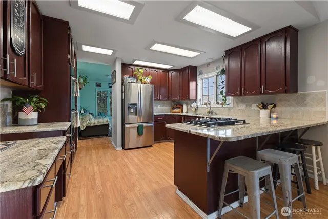 a kitchen with stainless steel appliances granite countertop a stove refrigerator sink and cabinets
