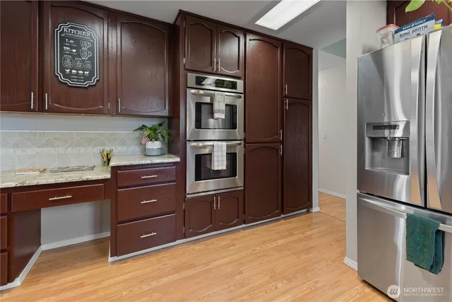 a kitchen with stainless steel appliances granite countertop a refrigerator and a stove top oven